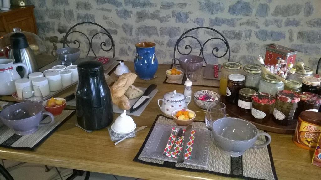 une table en bois avec beaucoup de nourriture et de boissons dans l'établissement Au Rendez vous de l'Auxois B&B, à Essey