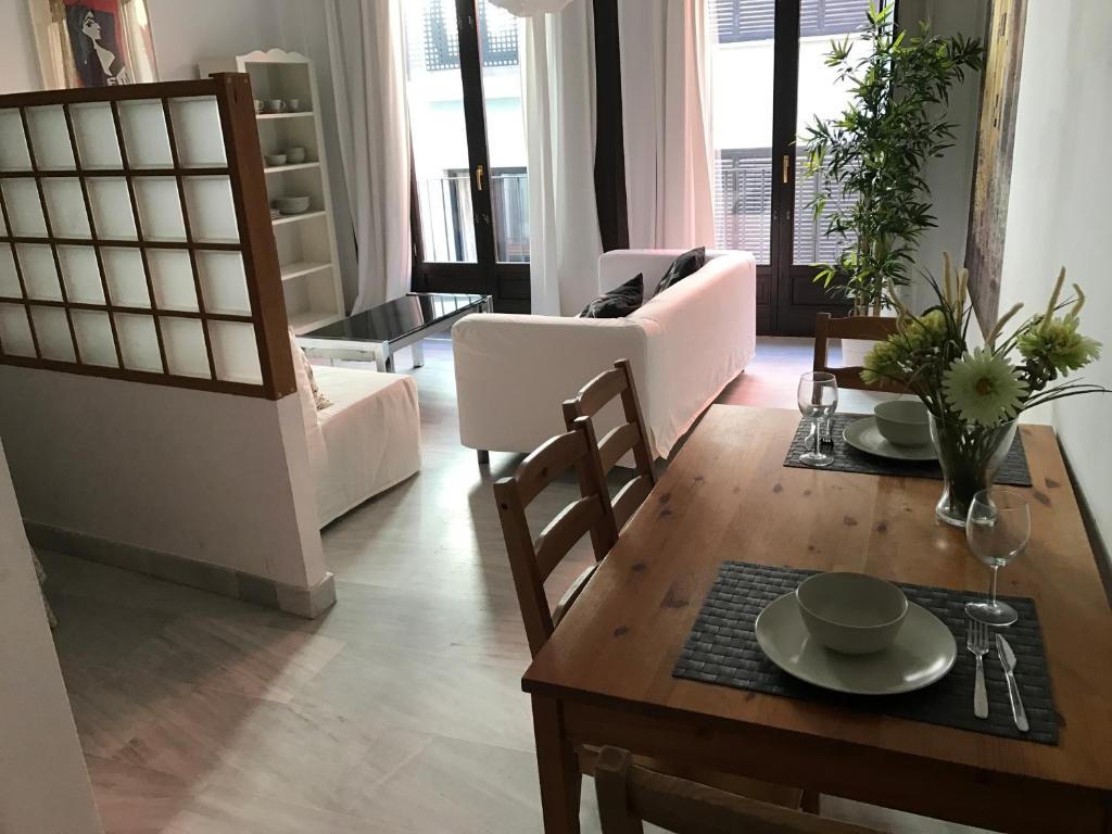 sala de estar con mesa y comedor en Málaga Apartamentos - Jinetes, 13, en Málaga