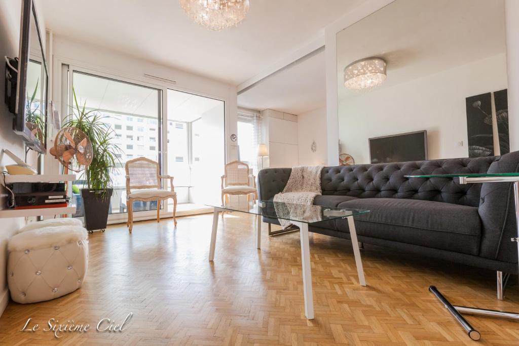 a living room with a couch and a glass table at Le Sixième Ciel in Lyon