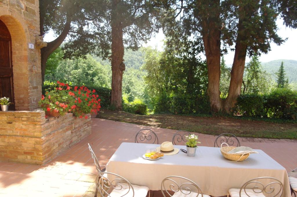 una mesa blanca y sillas en un patio en Antico Casale Rodilosso en Montaione