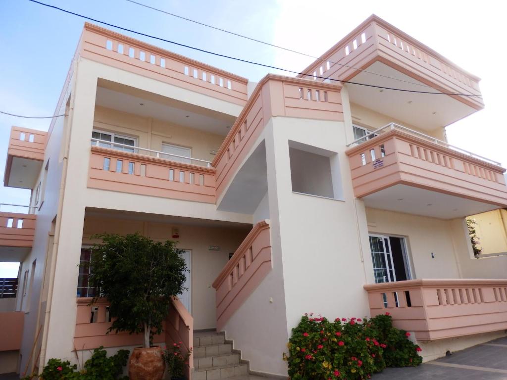 une maison avec des balcons et des fleurs devant elle dans l'établissement Babis Apartments, à Platanias