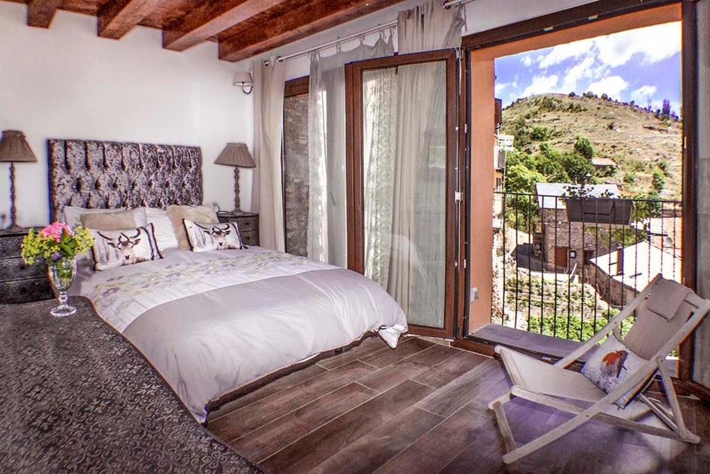 sypialnia z łóżkiem, krzesłem i oknem w obiekcie Cal Pastisser de Taús w mieście Tahús