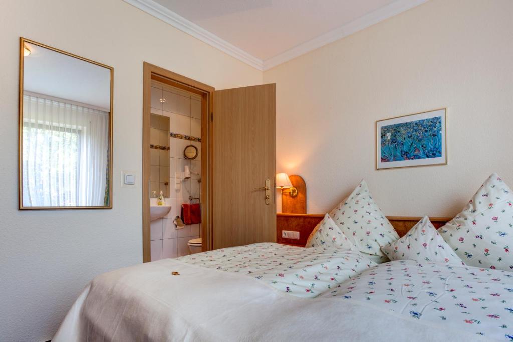a bedroom with a white bed with blue pillows at Der Westerwaldwirt Hotel Landhaus - Stähler in Hemmelzen
