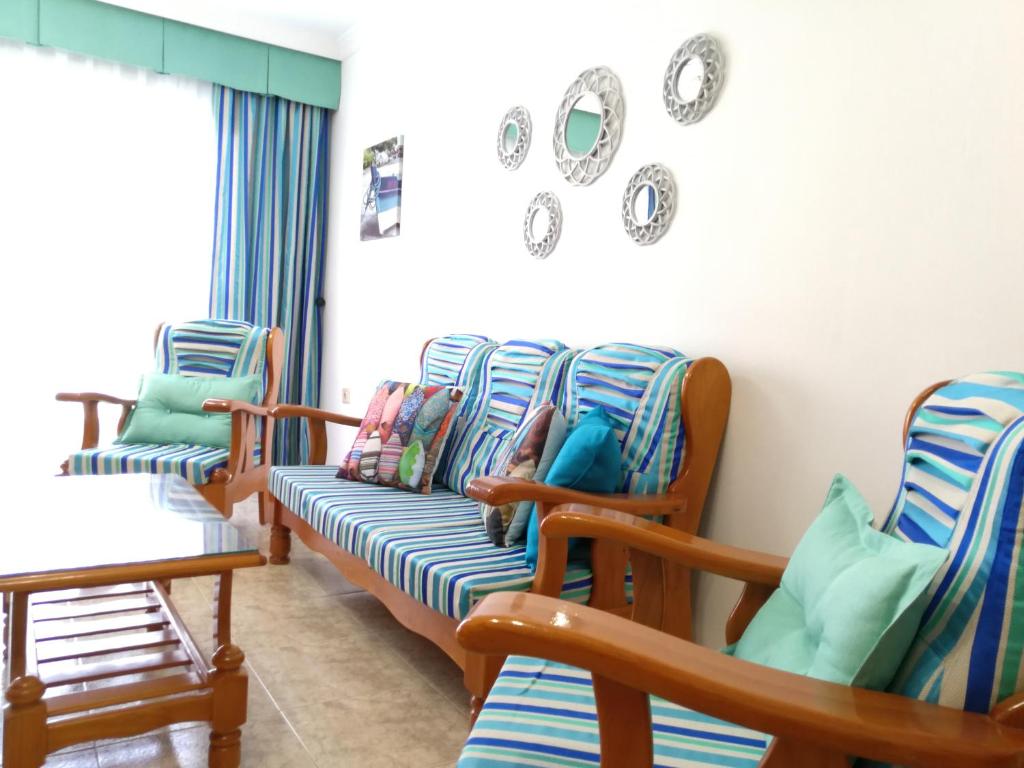 グラン・タラハルにあるApartamento Playa Gran Tarajalの時計付きの部屋の椅子