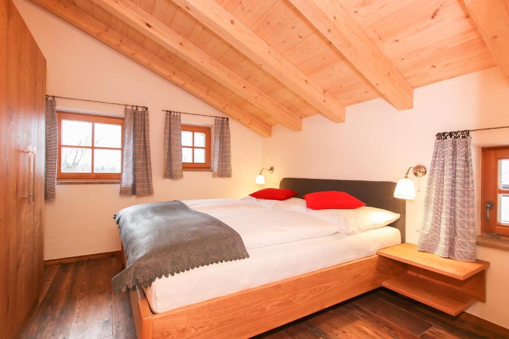 a bedroom with a large white bed with red pillows at Das Prinzis in Lofer