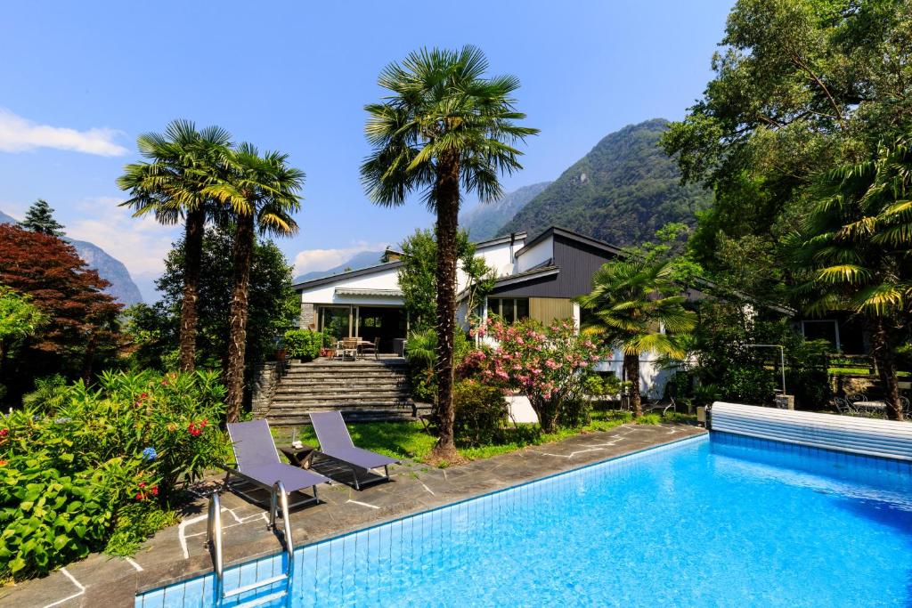 a house with a swimming pool and palm trees at Villa delle Palme in Coglio