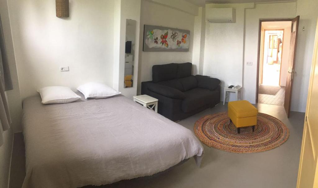 a bedroom with a bed and a chair and a couch at La Luna in Sóller