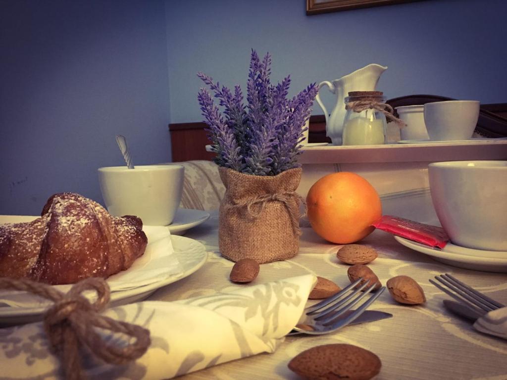 una mesa con pan, tazas de café y frutos secos en Hotel Malaga, en Avellino