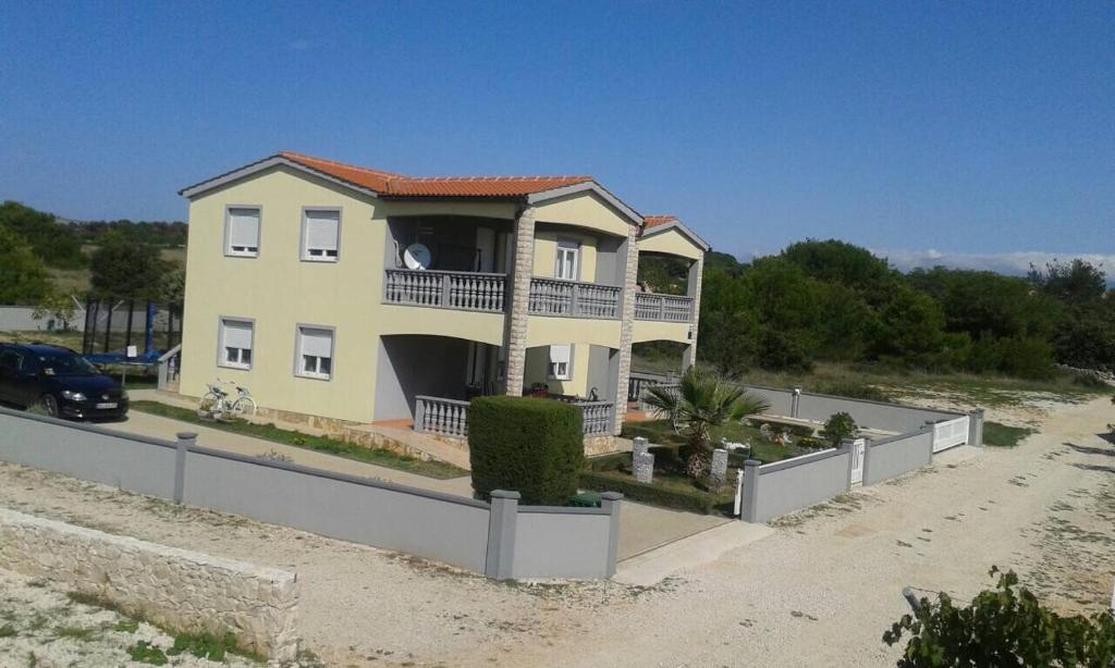 Casa amarilla con balcón en la playa en Apartments Duda en Vir
