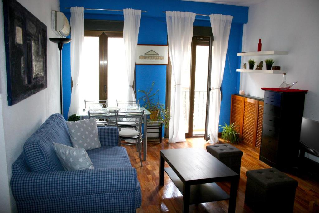 マドリードにあるCasa Pezの青い壁のリビングルーム(青いソファ付)