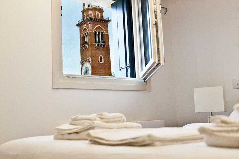 een slaapkamer met een klokkentoren door een raam bij Residenza Della Samaritana in Verona