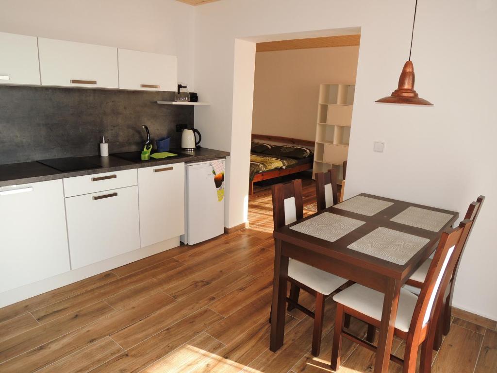 cocina y comedor con mesa y sillas en Apartmán 7, en Stožec