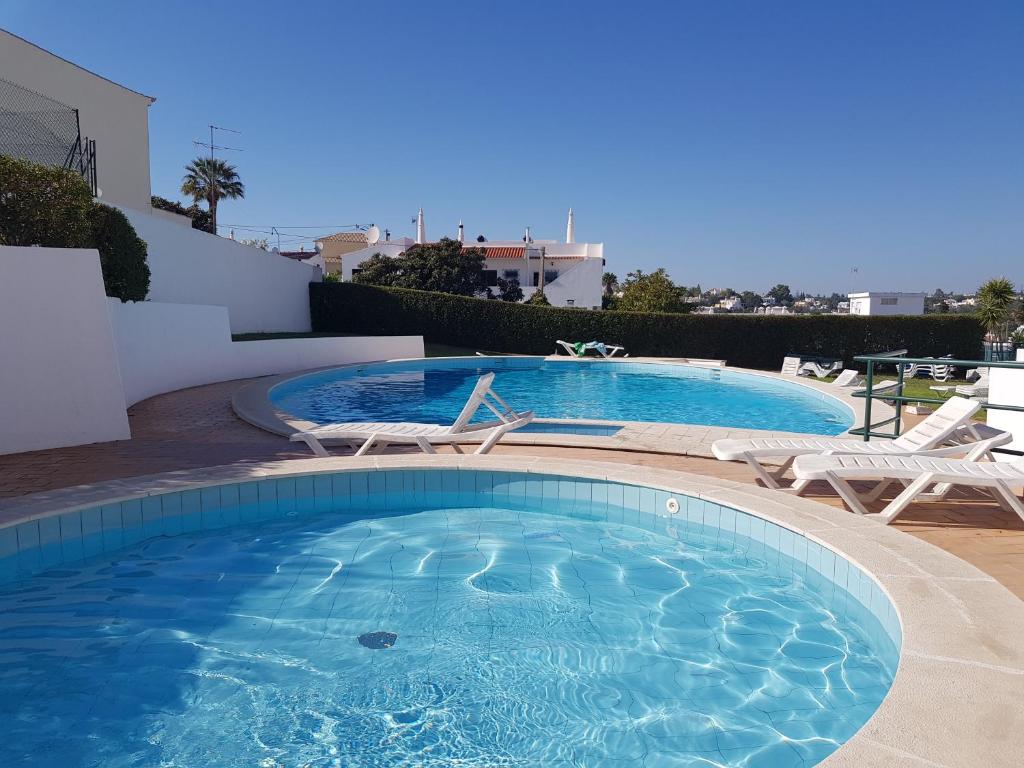 een groot zwembad met 2 stoelen en een tafel bij Casa da Ana in Carvoeiro