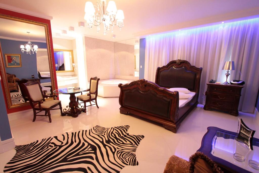 a bedroom with a zebra print rug and a bed at Miami Motel ( ADULT ONLY ) in Pindamonhangaba