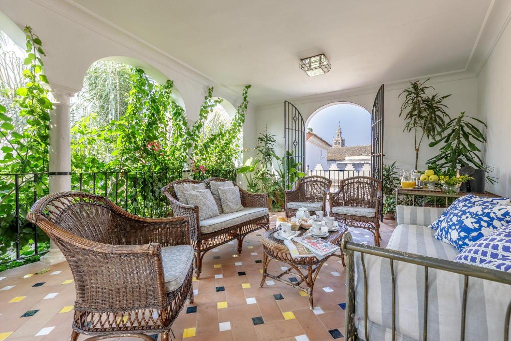 un patio con sillas de mimbre y una mesa en Casa Palacio San Jose, en Sevilla