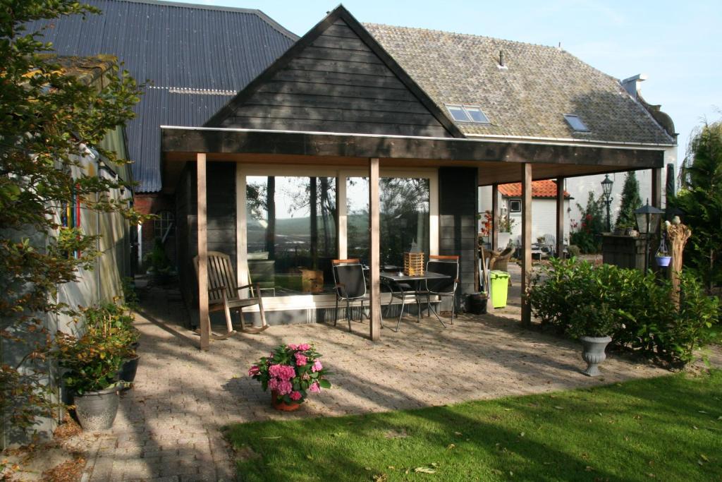 een paviljoen met een tafel en stoelen in een tuin bij BenB Zuidoord in Zuidland