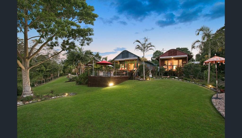 a house with a green lawn in front of it at Jetavana in Eudlo