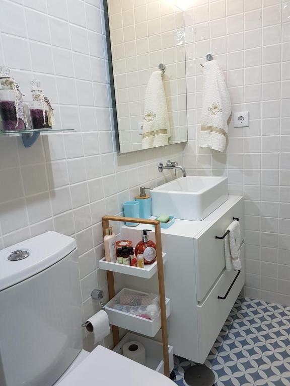 ein Badezimmer mit einem Waschbecken, einem WC und einem Spiegel in der Unterkunft Porto Belo Clérigos in Porto