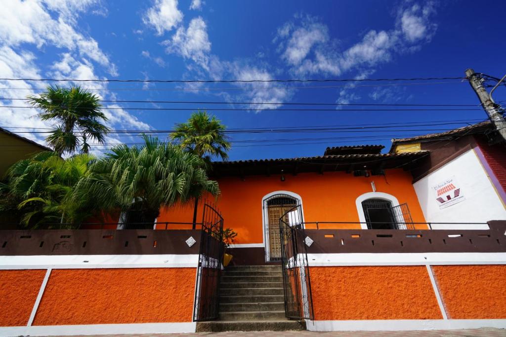 una casa arancione e bianca con un cancello e scale di El Arca de Noe a Granada