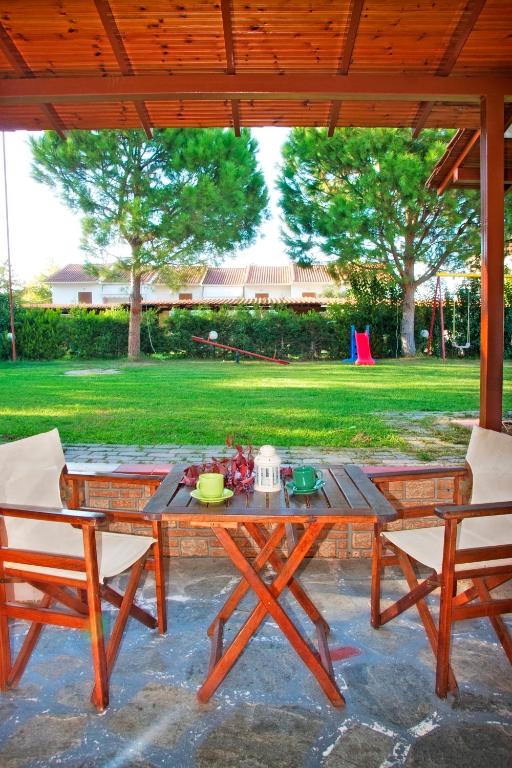 a picnic table and two chairs under a pavilion at Maria Village in Vourvourou