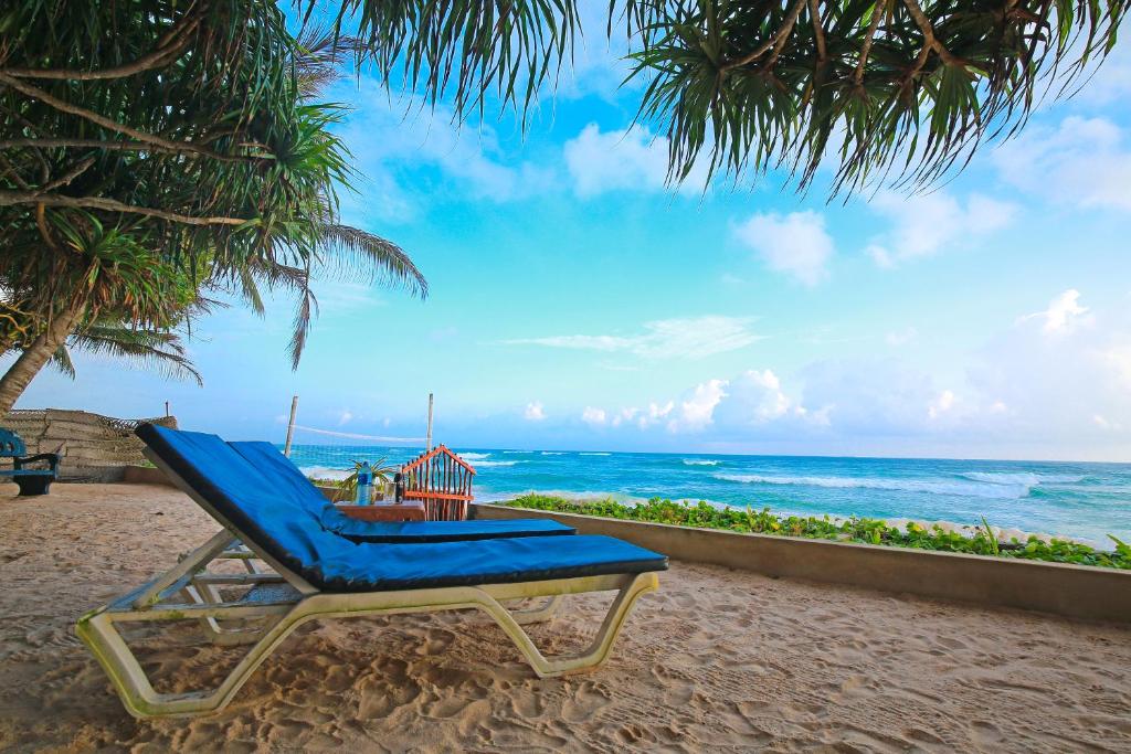 una silla de playa azul sentada en la playa en Haus am Meer "Wilde Ananas", en Koggala