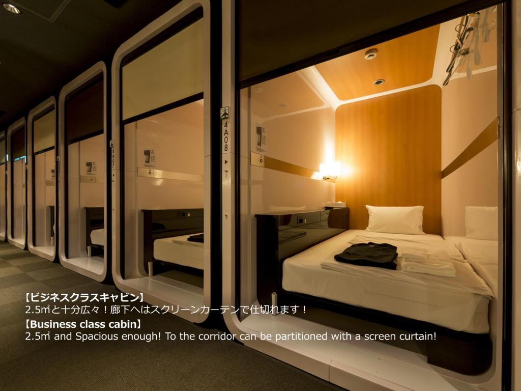 First Cabin Nagasaki في ناغاساكي: غرفه صغيره فيها سرير وبعض المرايا