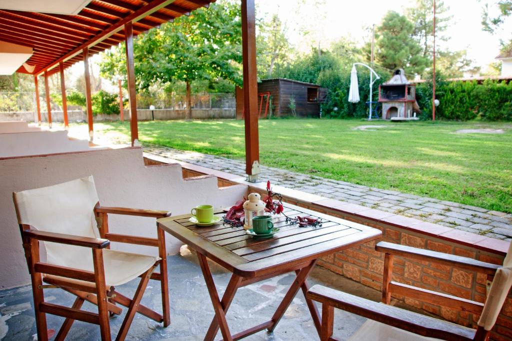 a table and chairs on a patio with a view of a yard at Maria Village in Vourvourou