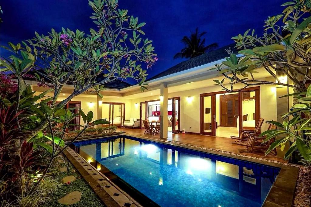 a swimming pool in front of a house at night at Villa Mantika in Senggigi 