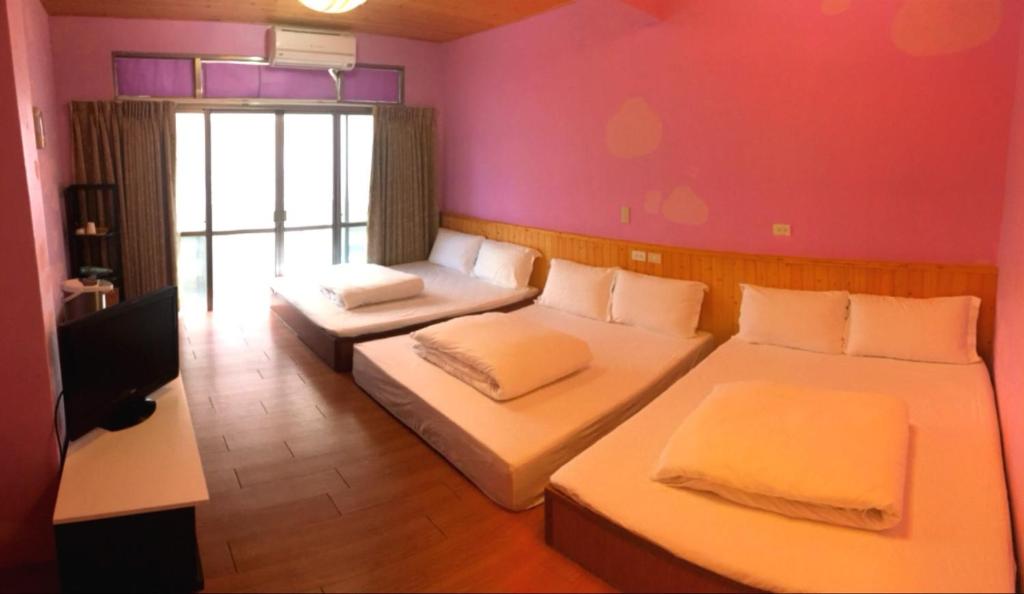 een kamer met 2 bedden en een tv. bij Shanputao Yi Zhan Homestay in Dawu