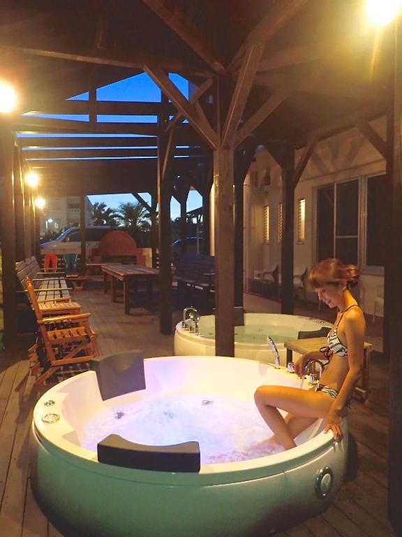 a woman sitting in a jacuzzi tub at Kerama Terrace in Tokashiki