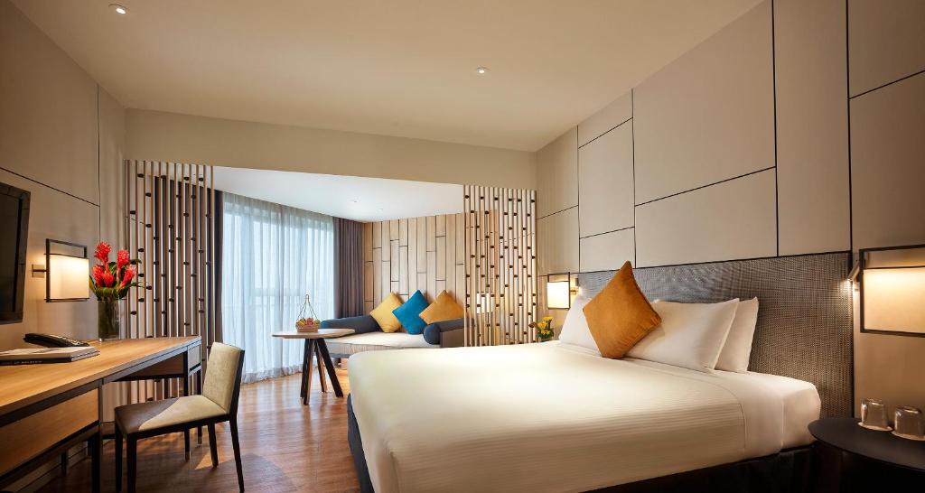 a hotel room with a bed and a desk at PARKROYAL Penang Resort in Batu Ferringhi