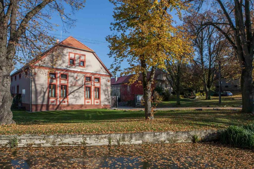 una casa vieja con puertas rojas en un patio en Agropenzion U Bartousku, en Malíkovice