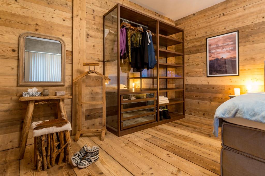 um quarto com paredes de madeira, uma cama e um closet em WOO® Loft Resort em Fiesch