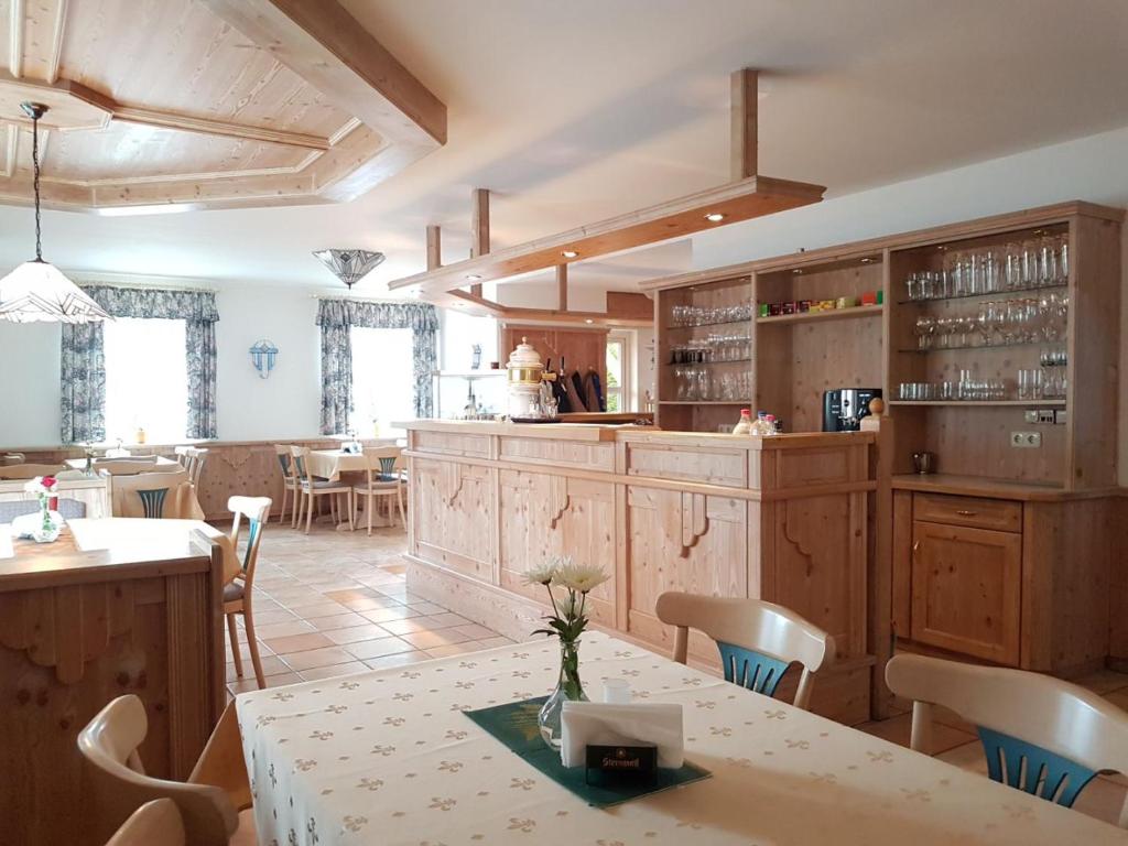 a kitchen with wooden cabinets and a table and chairs at Pension Nadia in Adorf