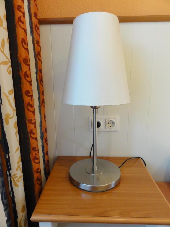a lamp sitting on top of a wooden table at Pension Zeitlos in Potsdam