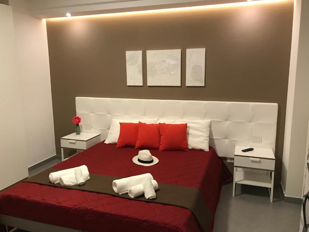 1 dormitorio con 1 cama grande con almohadas rojas y blancas en My Home, en Gravina in Puglia