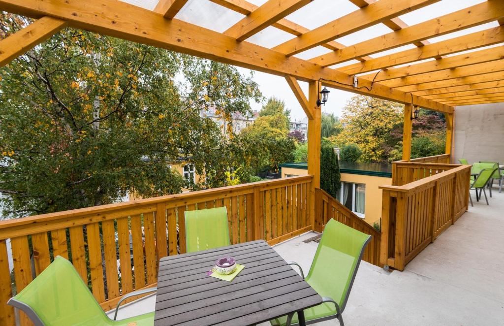 drewniany taras ze stołem i krzesłami w obiekcie Apartments Villa Luna w Wiedniu
