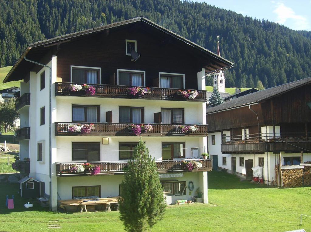 a large building with flowers on the balconies of it at Pension Anderlehof in Sankt Lorenzen im Lesachtal