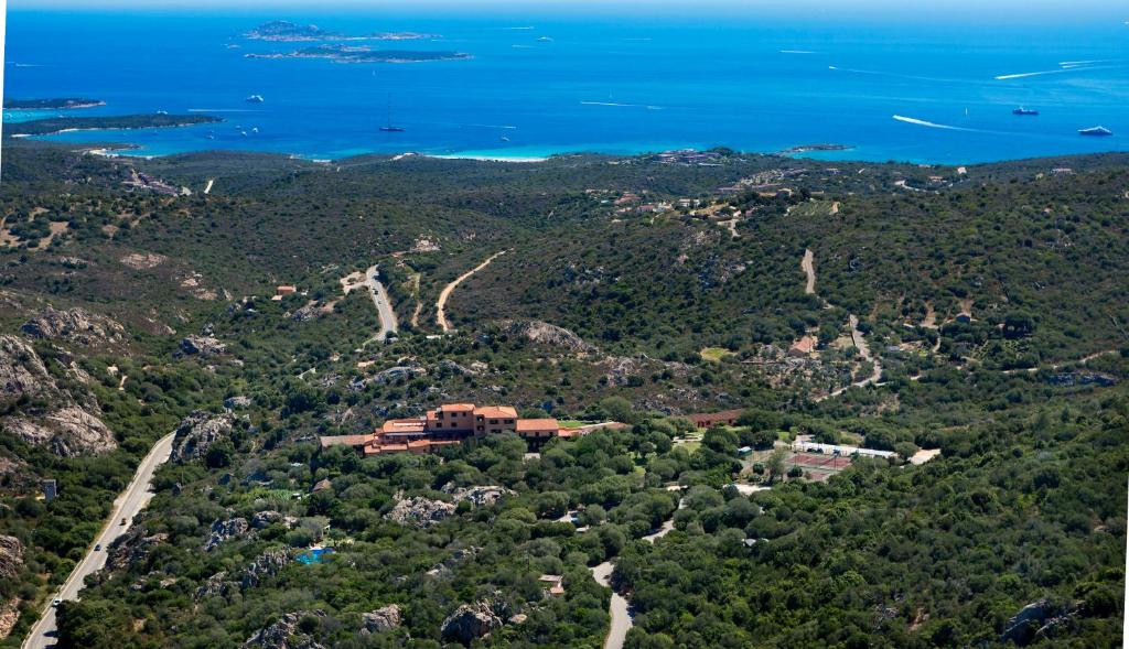 una vista aerea di un resort su una collina con l'oceano di Hotel Rocce Sarde a San Pantaleo