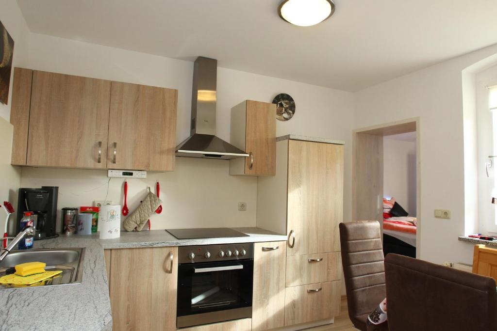 een keuken met houten kasten en een fornuis met oven bij Ferienwohnung Kopp II in Greiz