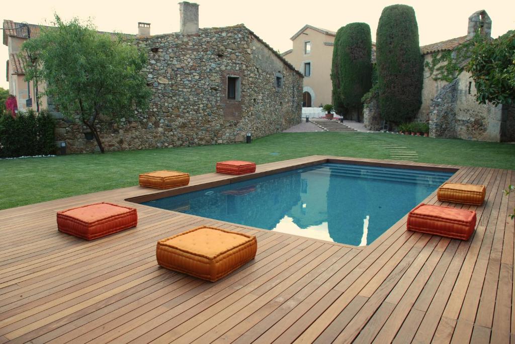 una terraza con piscina y algunas sillas acolchadas en Mas Vives, en Cabrils