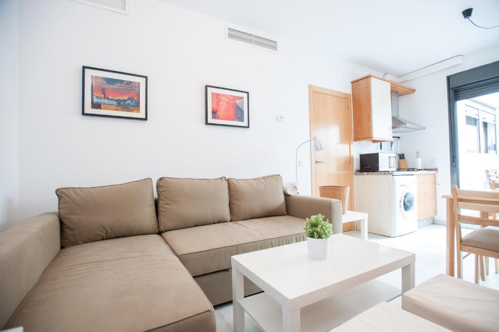 - un salon avec un canapé et une table dans l'établissement Apartamento San Bernardo, à Séville