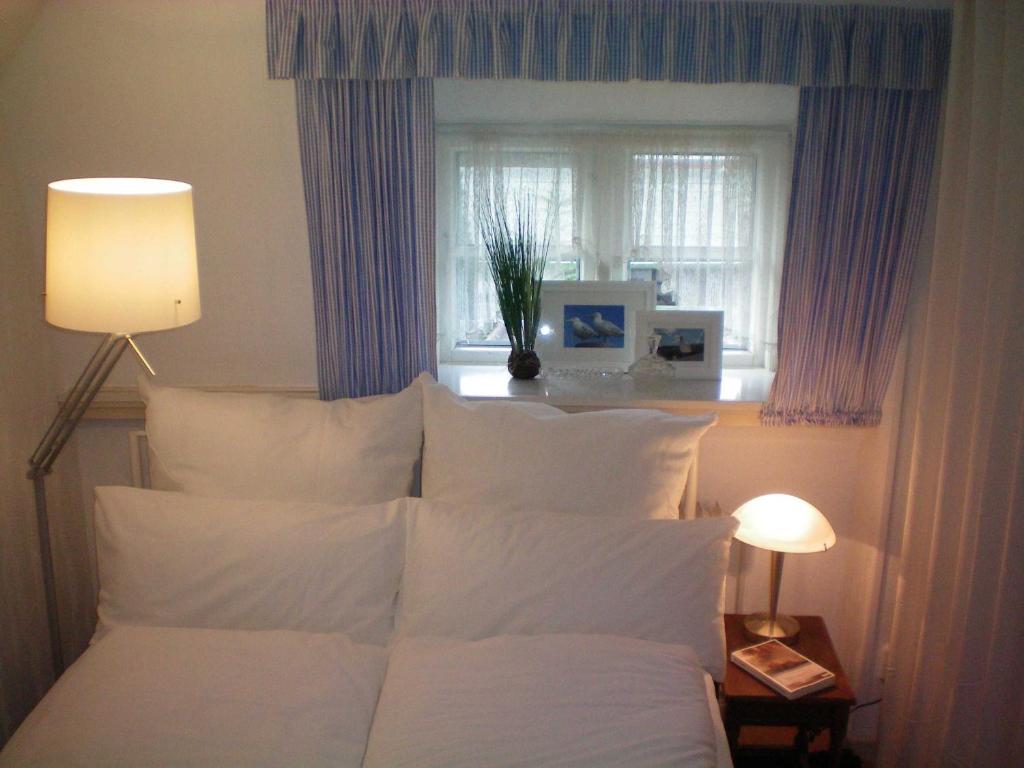 Risum-LindholmにあるFerienhaus Klookris 15のベッドルーム1室(白い枕のベッド1台、窓付)