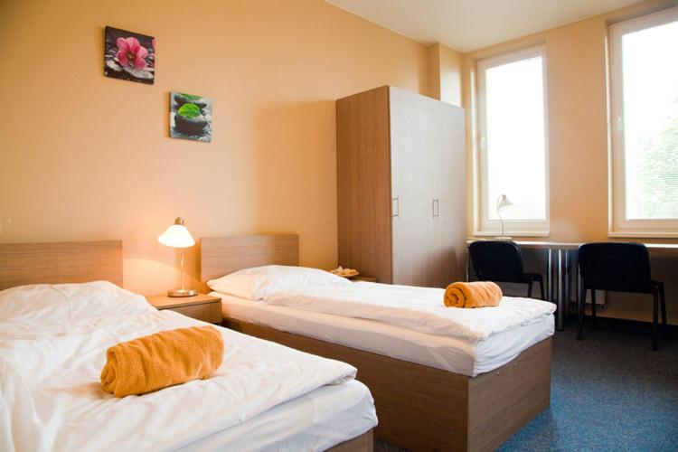 a hotel room with two beds with towels on them at Penzion s wellness Uherské Hradiště in Uherské Hradiště