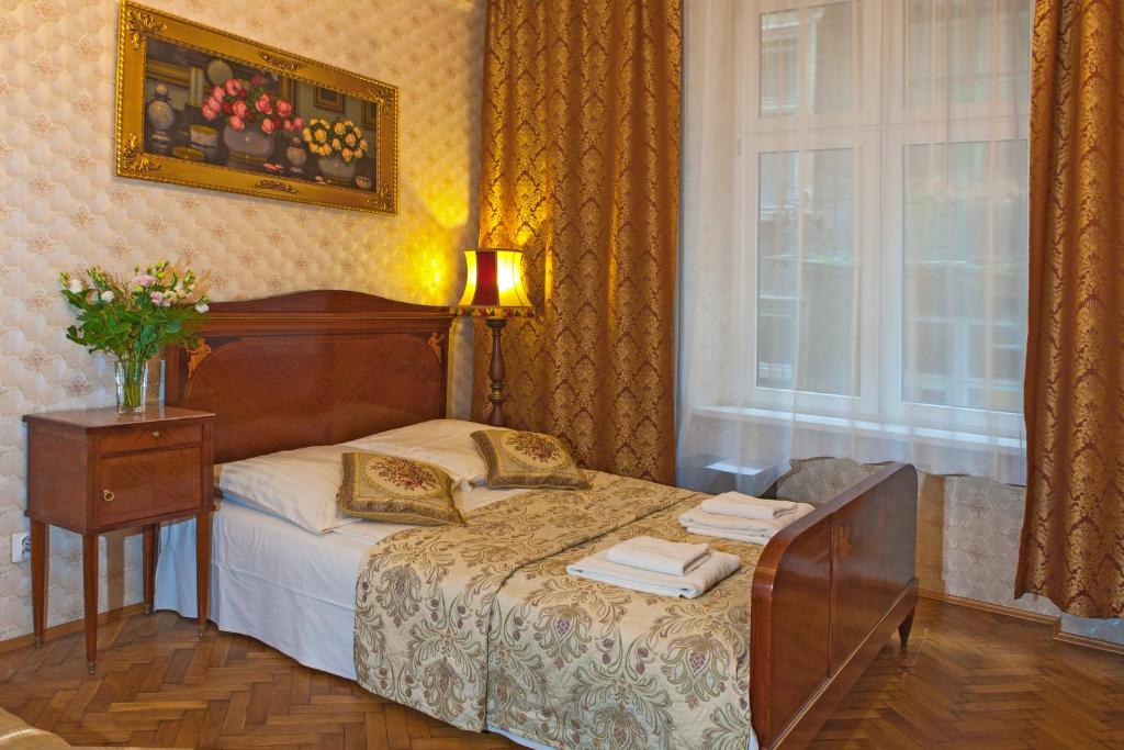 a bedroom with a bed with a table and a window at Metropolitan Apartments in Krakow