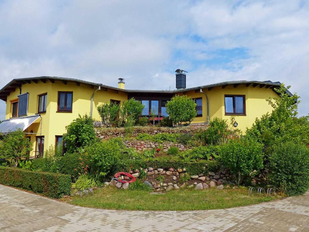 a yellow house with a garden in front of it at Im Sternhaus Waren Müritz in Waren