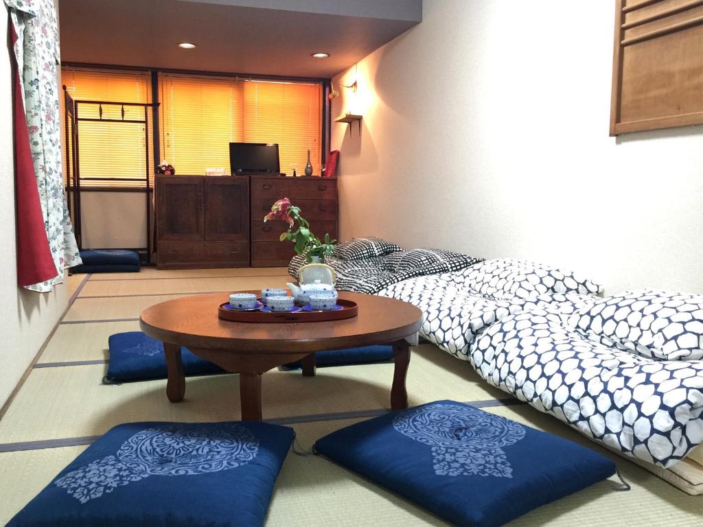 een woonkamer met 2 bedden en een tafel bij Tsukiji Hostel Wakayama 1 in Wakayama