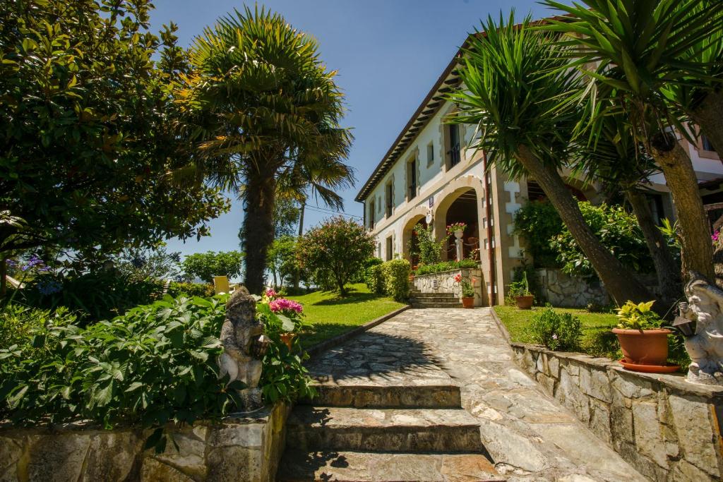 a house with palm trees and a walkway at Posada Rio Cubas in Cubas