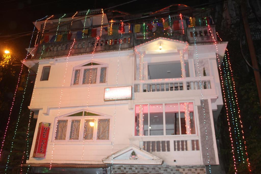 a white house with christmas lights on it at Happy Valley Homestay in Darjeeling