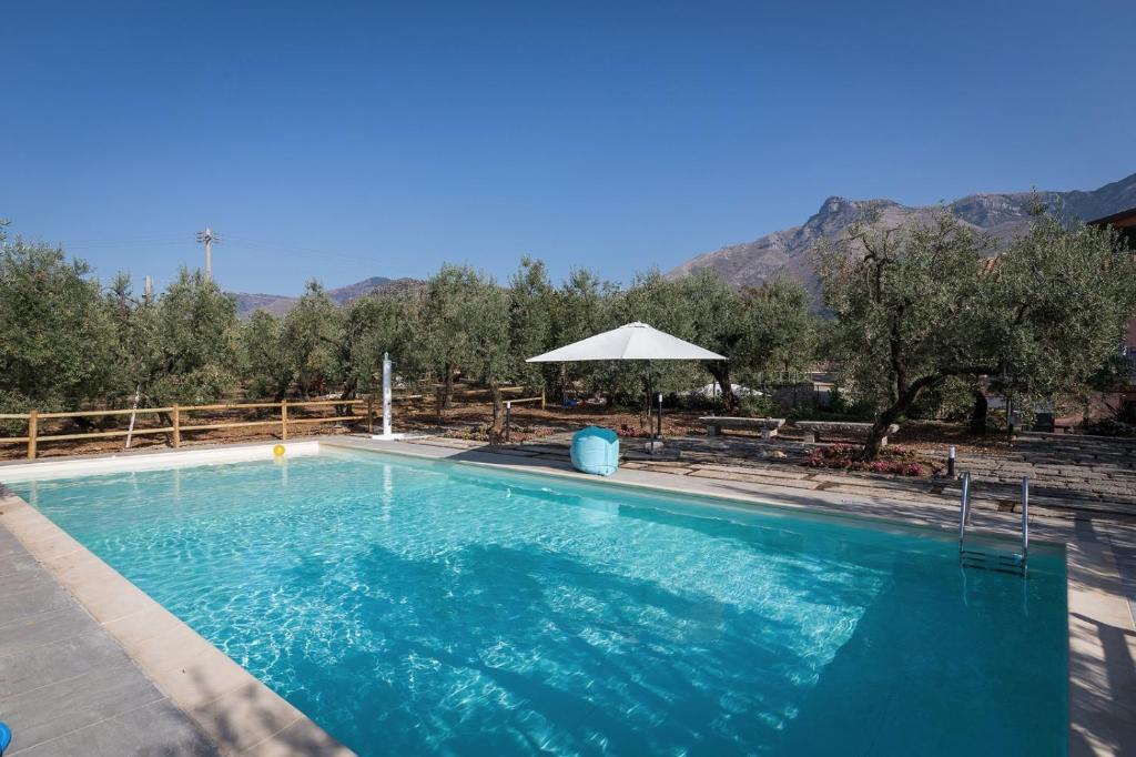 a large blue swimming pool with a mountain in the background at Il Finto Pepe B&B in Formia